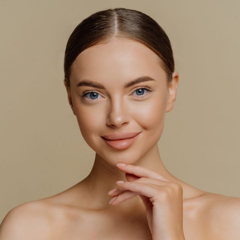 Headshot,Of,Beautiful,Brunette,Woman,Touches,Jawline,Looks,Directly,At